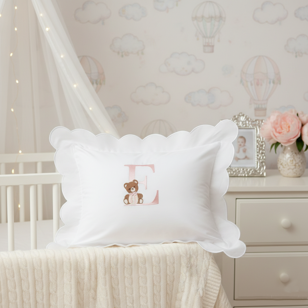 White pillow with teddy bear design in a nursery setting