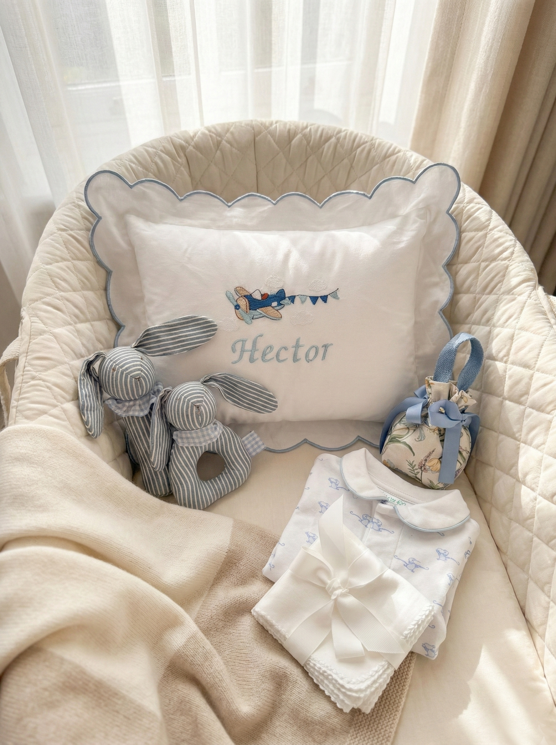 Baby crib with decorative pillow, rattle, and blanket in a cozy setting.